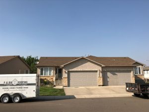 Completed residential roof with P & BW Roofing trailer in the picture to the left side.