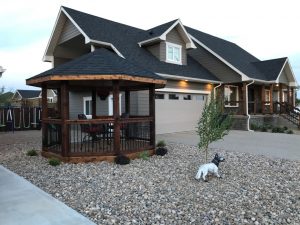 Completed Gazebo construction and roofing with black shingle roof and dark stained wood.